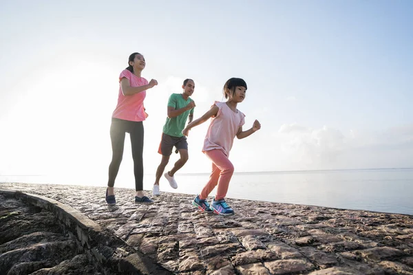 Padres asiáticos y niños corriendo deporte al aire libre. —  Fotos de Stock