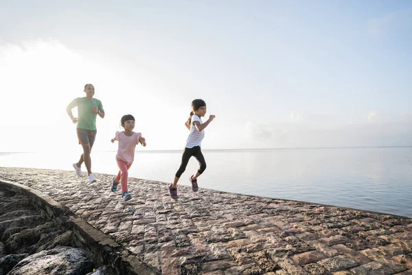 Vader en dochter doen oefeningen lopen outdoor racen elkaar — Stockfoto