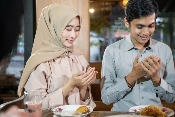 Laki-laki dan perempuan berkerudung berdoa bersama sebelum makan sambil berbuka puasa — Stok Foto