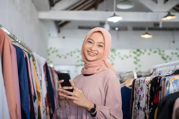 Uma jovem mulher de negócios usando um hijab segurando um celular — Fotografia de Stock