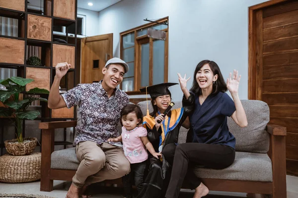 Feliz asiática familia graduado en casa. estudiante de primaria en casa celebrando — Foto de Stock