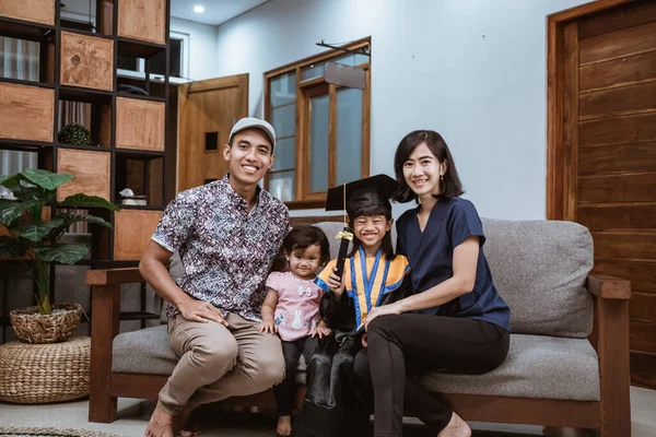 Glückliche asiatische Familienabsolventen zu Hause. Grundschüler feiern zu Hause — Stockfoto