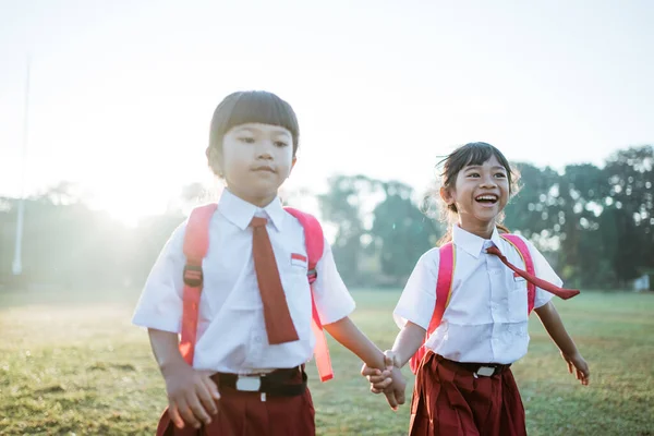 Lågstadieelev vän bär indonesisk uniform går i skolan — Stockfoto