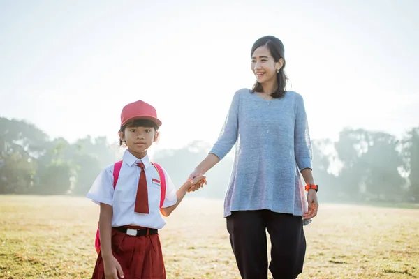 Mutter geht ihr Kind morgens zur Schule — Stockfoto