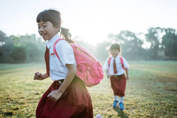 Μικρό κορίτσι μαθήτρια τρέχει μαζί, ενώ πηγαίνει στο σχολείο τους — Φωτογραφία Αρχείου