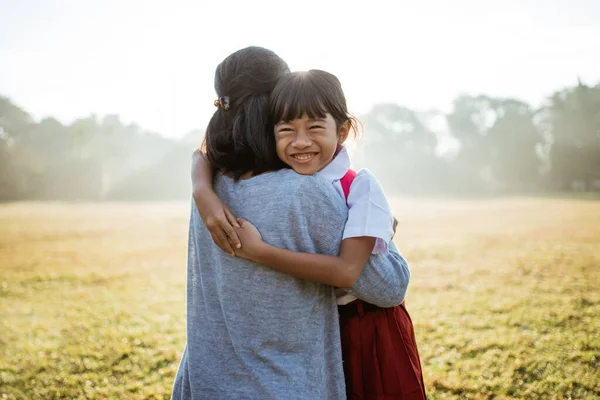 Asiatico madre abbraccio e abbraccio il suo figlia andando a scuola — Foto Stock