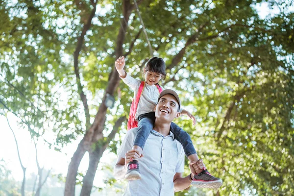 Daughter sitting on fathers shoulder when going to school — Stock Photo, Image