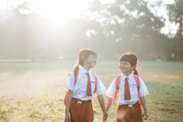 幸せな女子アジア小学校の生徒が一緒に歩く — ストック写真