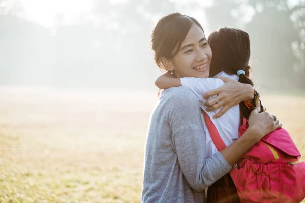 Asiatico madre abbraccio e abbraccio il suo figlia andando a scuola — Foto Stock