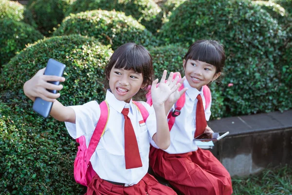 Bästa vän till indonesiska grundskoleelev ta selfie — Stockfoto