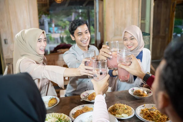 Gruppe junger Asiaten feiert und hebt Gläser mit Fruchteis zum Toast während des Fastenbrechens — Stockfoto
