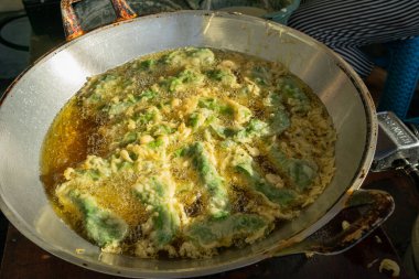 Kızartma tavasında un ile kızartılan ıspanak yaprakları.