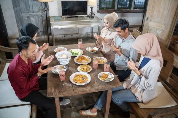 两名穆斯林男子和三名蒙面女子在吃饭前一起祈祷 — 图库照片