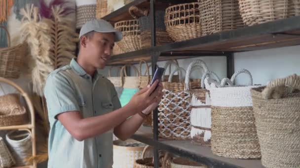 Joven empresario usando su teléfono en el taller — Vídeo de stock