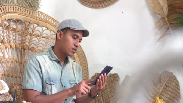 Ung entreprenör som använder sin telefon på verkstad — Stockvideo