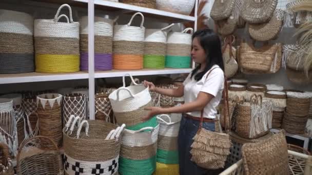 Mulher asiática levanta cestas de vime de pé entre os itens de artesanato — Vídeo de Stock