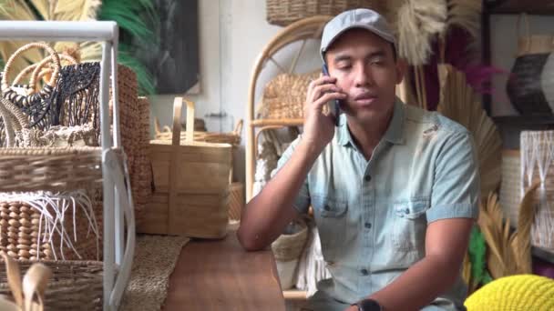 Fiatal vállalkozó használja a telefont a műhelyben — Stock videók