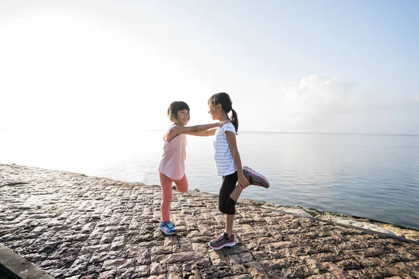 Athletic crianças fazendo alongamento pernas exercícios juntos — Fotografia de Stock