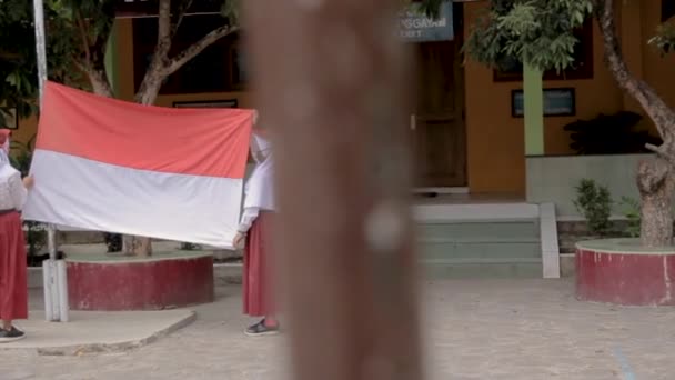 Étudiant hissant le drapeau indonésien à l'école primaire — Video