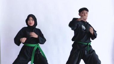Pencak silat üniforma giyen Asyalı erkek ve kadınlar kavga ediyor