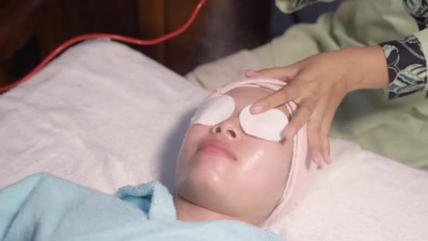 Молода жінка розслабляється при лікуванні обличчя — стокове відео