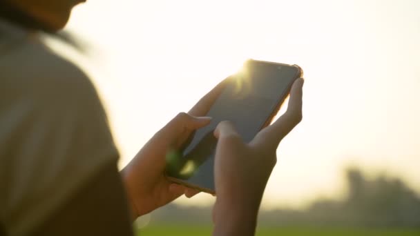 Porträt eines schönen jungen Mädchens, das in der Hand eines Mobiltelefons schaut — Stockvideo