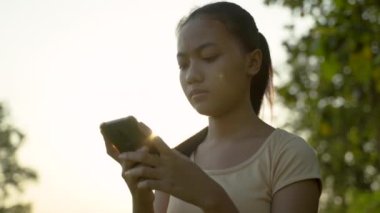 Elinde cep telefonu olan güzel bir kızın portresi.