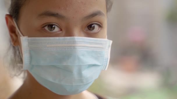 Nahaufnahme von Teenager-Mädchen trägt eine Maske, während sie vor dem Ausgehen sitzt — Stockvideo