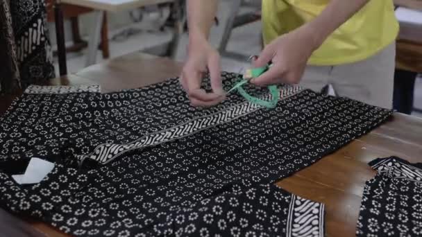 A costureira mede cuidadosamente a roupa com uma régua — Vídeo de Stock