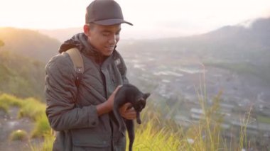 Sırt çantalı maceraperest bir adam kedi ile anı yakalıyor..