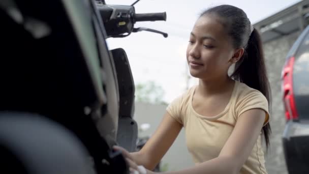 Hermosa adolescente lavar su moto scooter — Vídeo de stock