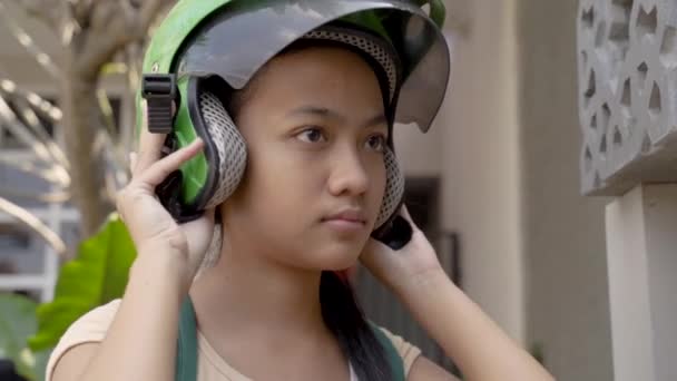 Hermosa joven está sentada en su motocicleta con casco en casa — Vídeos de Stock