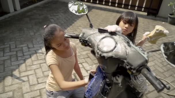 Potrait feliz chica joven y niña lavando motocicleta — Vídeos de Stock