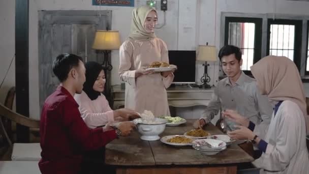 Meninas em hijabs e alguns homens se reúnem e comem juntos na sala de jantar — Vídeo de Stock