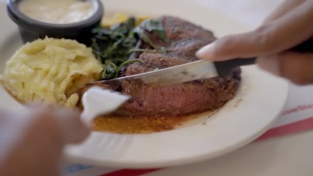 Comiendo un bistec. primer plano de la mano que tiene filete de carne de res mediana — Vídeos de Stock