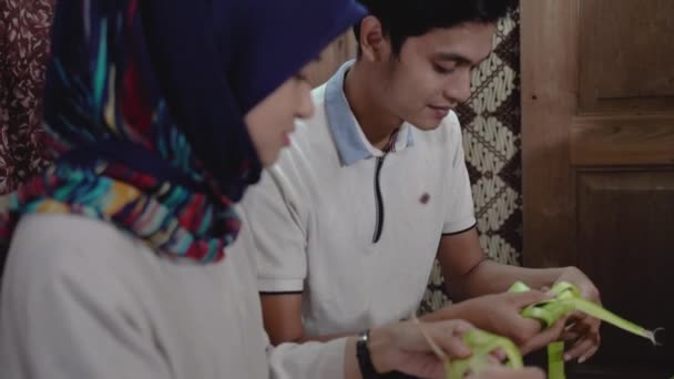 Família muçulmana e amigo fazendo ketupat para eid fitr mubarak — Vídeo de Stock