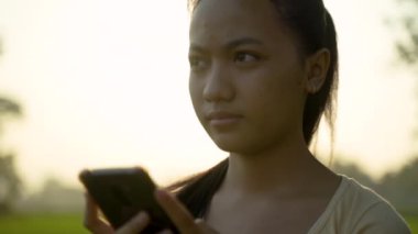 Elinde cep telefonu olan güzel bir kızın portresi.