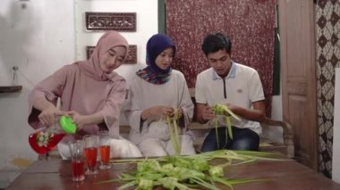 Müslüman ailesi ve arkadaşı bayram için ketupat yapıyor.