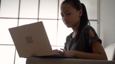 Güzel bir öğrenci evdeki kanepede oturup ders çalışıyor.