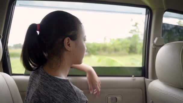 The teenage girl looks outside while sitting in the car with the windows open — Stock Video