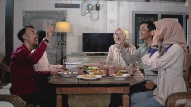Chicas en hijabs y algunos hombres se reúnen y comen juntos en el comedor — Vídeos de Stock