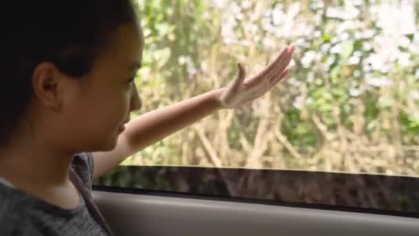 The teenage girl looks outside while sitting in the car with the windows open — Stock Video