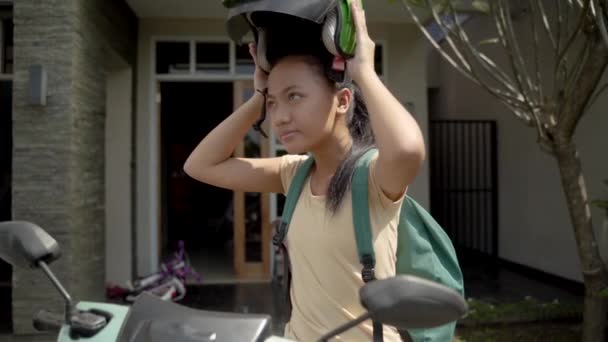 Hermosa joven está sentada en su motocicleta con casco en casa — Vídeos de Stock