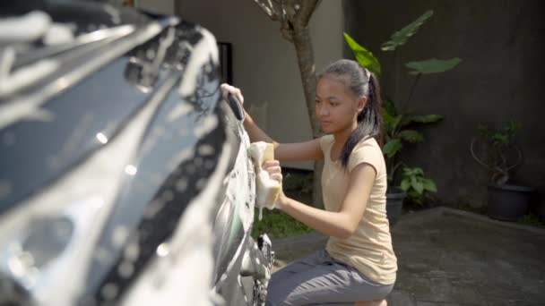 Азиатская молодая девушка моет мотоцикл с мылом и губкой — стоковое видео
