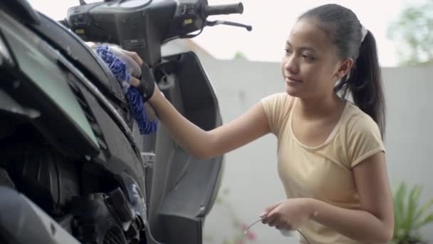 Asijské mladé dívka mytí jeho motocykl skútr s mýdlem a houbou — Stock video