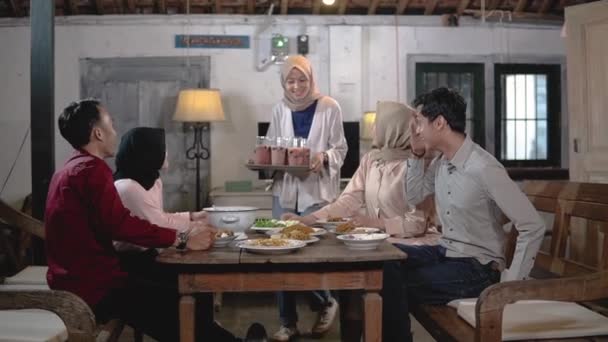 Meninas em hijabs e alguns homens se reúnem e comem juntos na sala de jantar — Vídeo de Stock