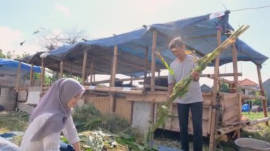 Müslüman adam ve kadın çiftçi hayvan besliyor.