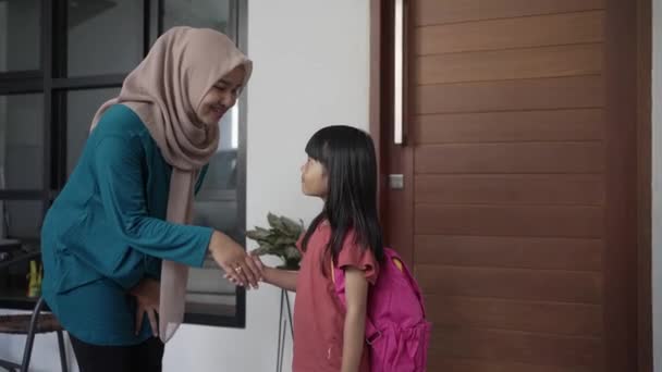 Ученица начальной школы пожимает руку и целует своих мусульманских матерей — стоковое видео