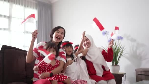 Entusiasta partidario de la familia indonesia mientras ve el partido deportivo en la televisión en casa — Vídeo de stock