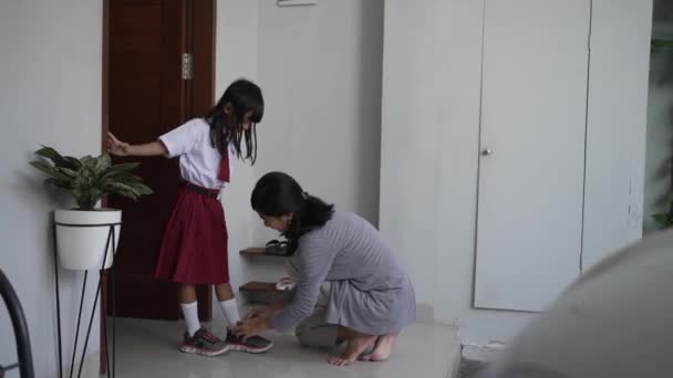 Мать помочь дочери носить обувь по утрам — стоковое видео